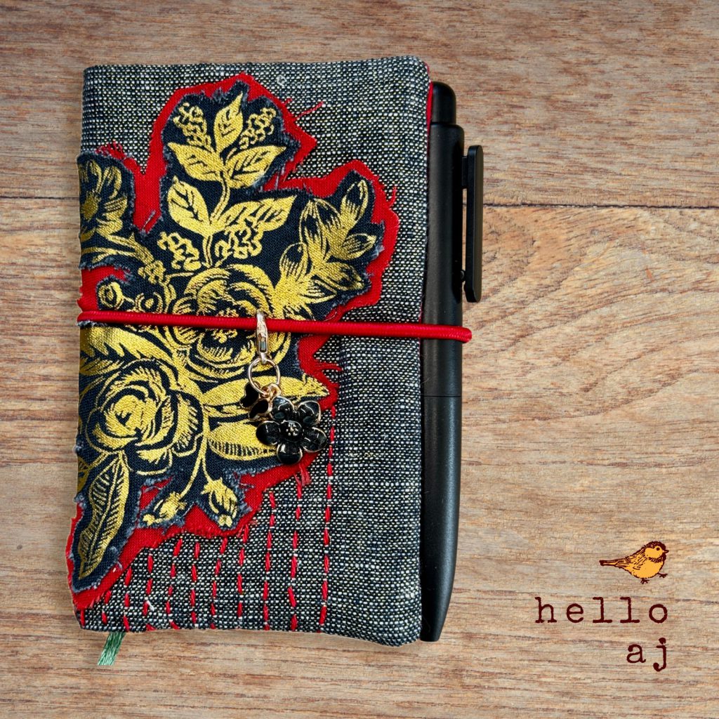 handmade navy tweed journal cover with gold raw edge floral applique and red elastic closure – hello.aj