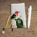 handmade linen journal cover with raw edge applique bird design, shown on journal with elastic closure – hello.aj